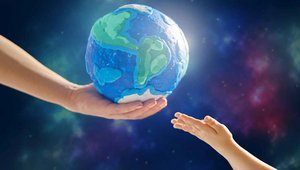 Hand hält eine Weltkugel und eine Kinderhand ist ausgestreckt
